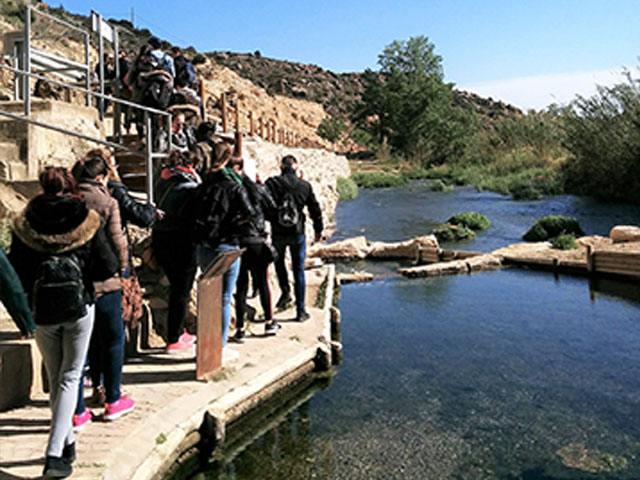 Grupo de estudiantes de la escuela de turismo de la Universidad de Zaragoza visitando los manantiales termales de Ariño, Teruel